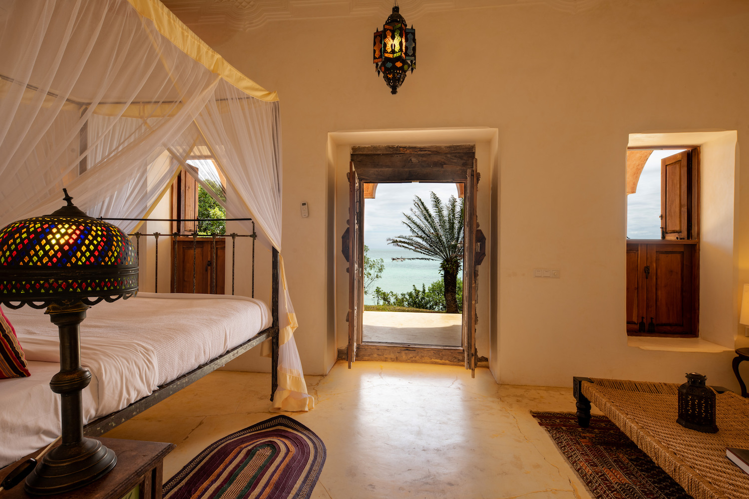 Qambani Luxury Resort Zanzibar Hotel - Sundowner Villa bedroom with view out of door onto the veranda and out to the Indian Ocean