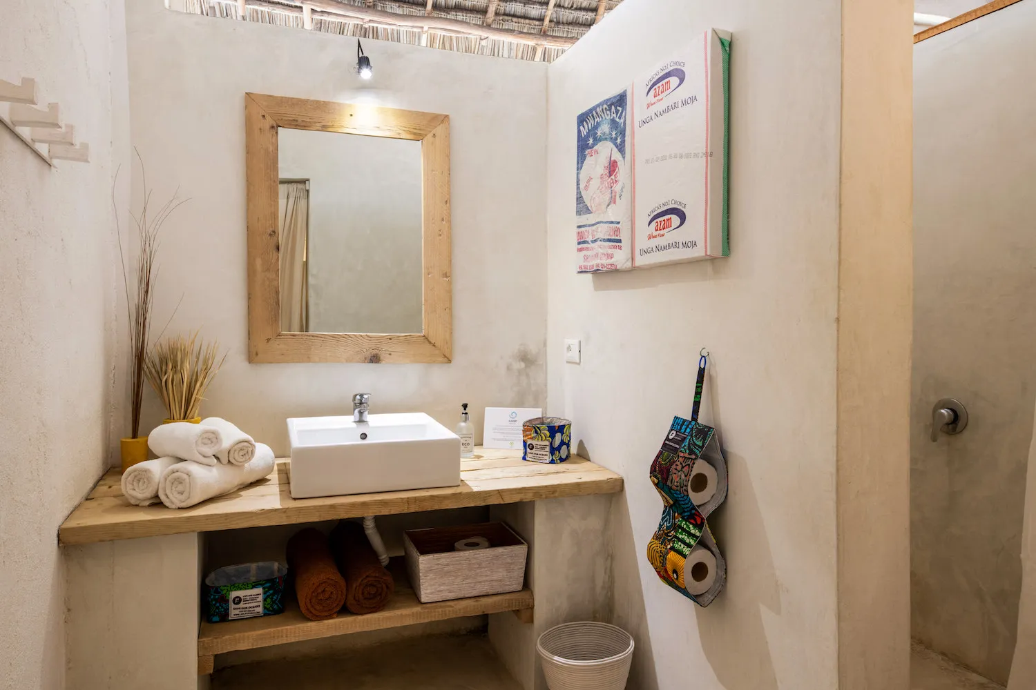 Zanzibar hotel The Loop Beach Resort bathroom with sink, mirror, towels and shower Our Zanzibar Hotel Group