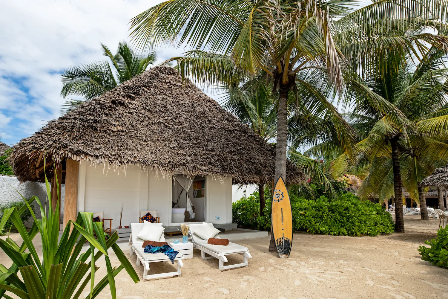 Zanzibar hotel The Loop Beach Resort sun-loungers, surfboard and foliage outside suite room Our Zanzibar Hotel Group