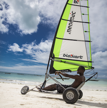 Zanzibar hotel The Loop Beach Resort man riding wind sail buggy on beach Our Zanzibar Hotel Group