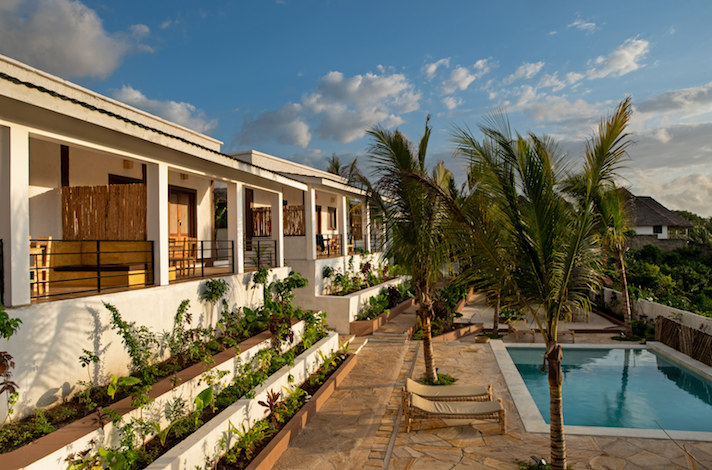 Our Zanzibar Group Nyumbani Residence pool palm trees and apartments at sunrise