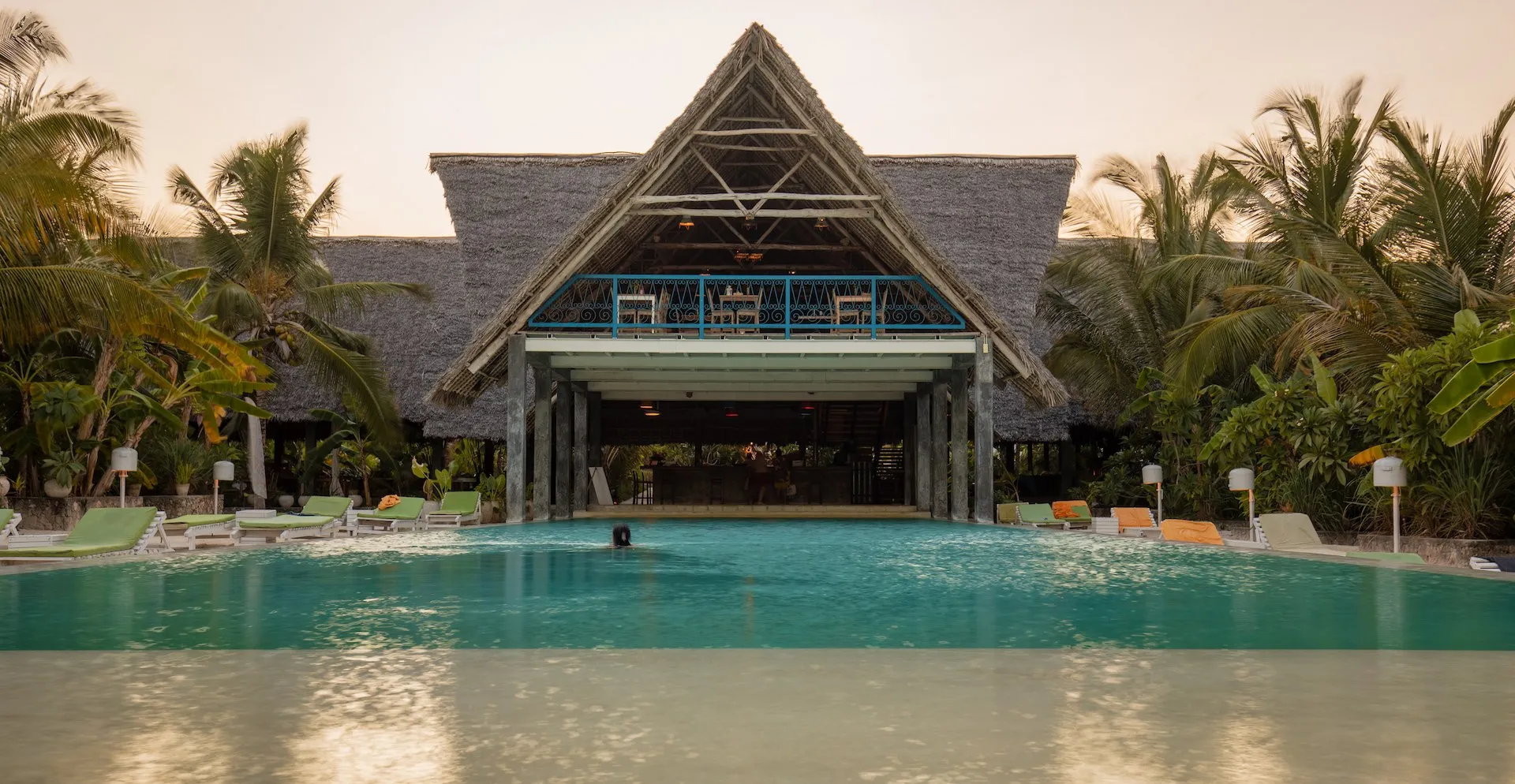 Fun Beach Hotel Zanzibar pool with guest at sunset